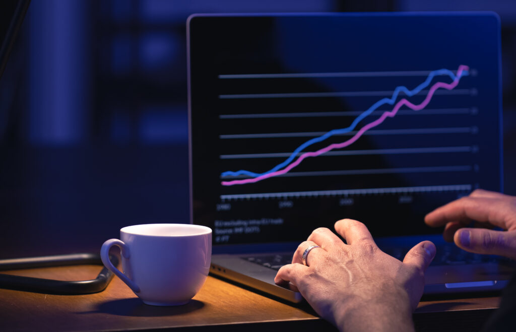 Broker looking at laptop analyzing stock market invest trading stocks graph. trading para ganar dinero online